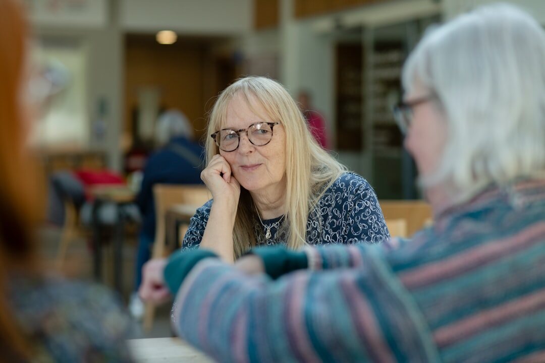 Kleines Redaktionsteam sitzt gemeinsam an einem Tisch und bespricht Layouts